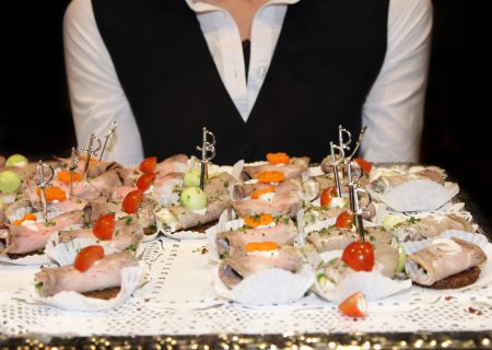 Waitress serving finger food. In the foreground, the tray can be seen with the appetizers. - Textile-square